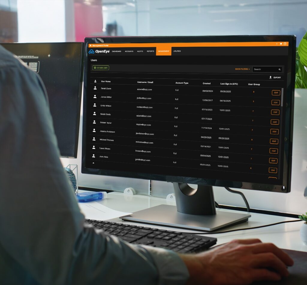 A man is focused on a computer displaying a list of OpenEye Web Services users