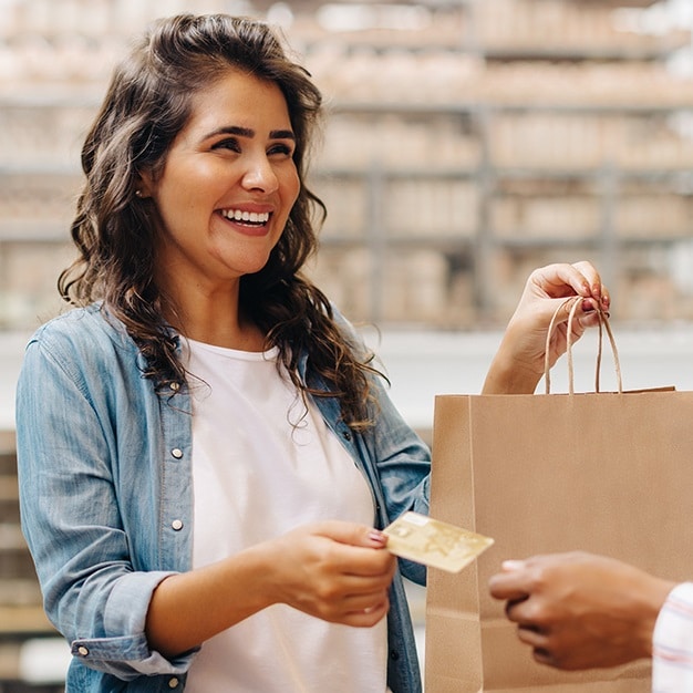 Smiling woman paying for item with a credit card