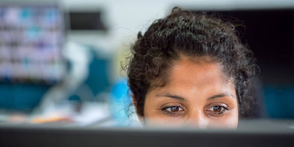 A woman looks at a computer screen