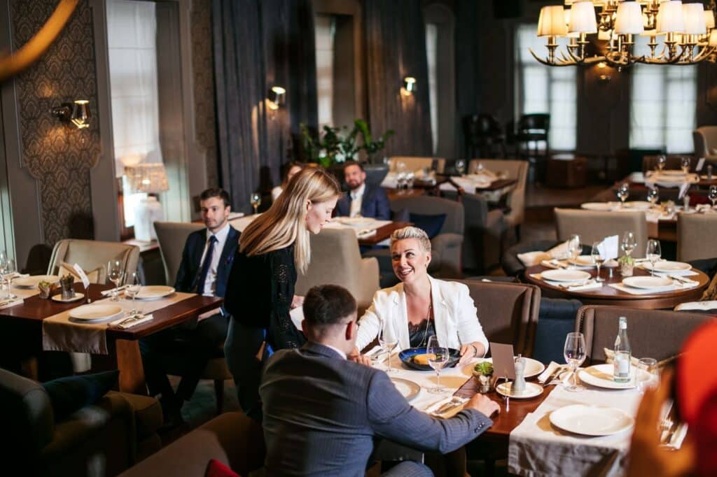 A waitress serves a couple at a fine dining restaurant&nbsp;