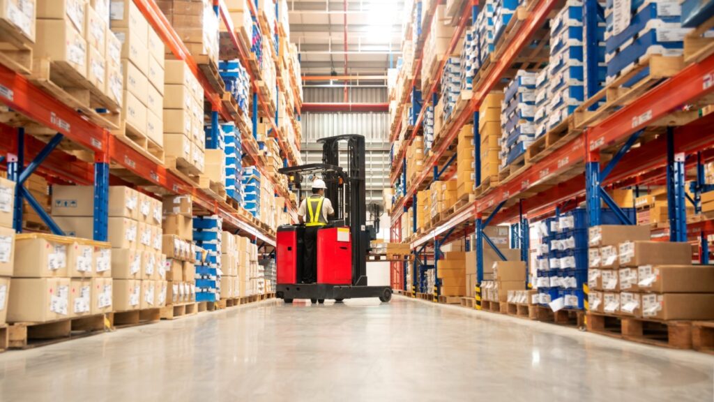 A person on a forklift in a warehouse.