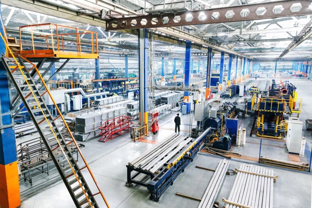 An employee walks through an industrial facility equipped with multiple types of machinery
