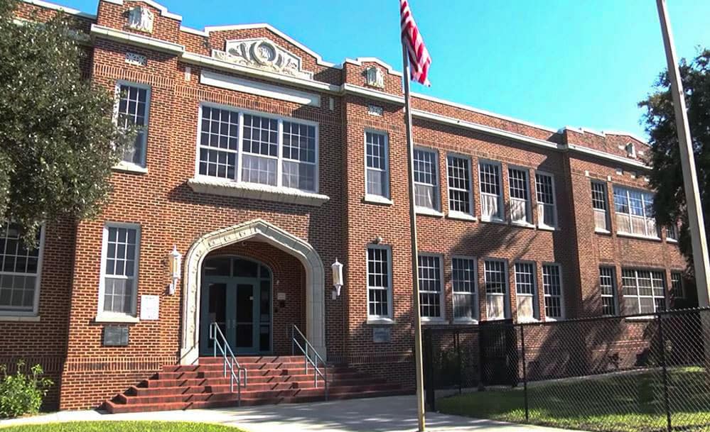 External view of an entrance to a two-story brick school building