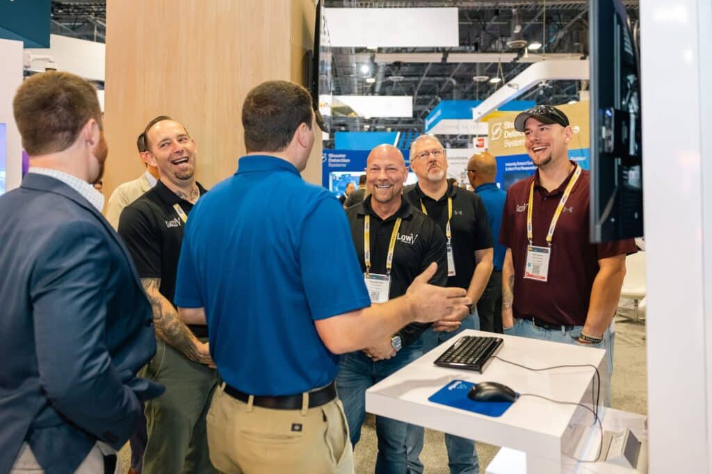 A group of men interacting in an OpenEye booth during an event