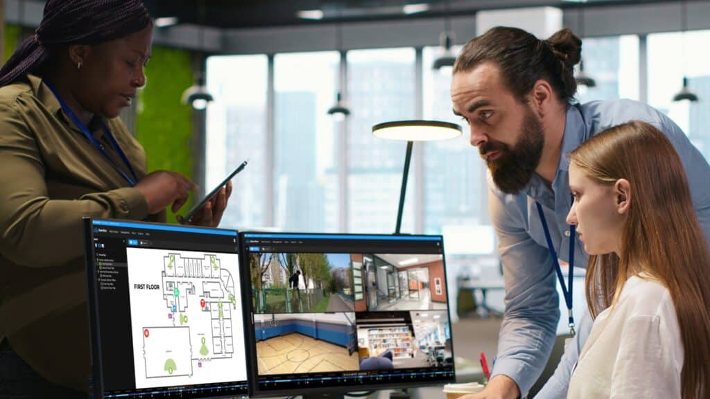 A group of educational professionals gathered around a computer screen displaying OpenEye Web Services and Cloud Maps