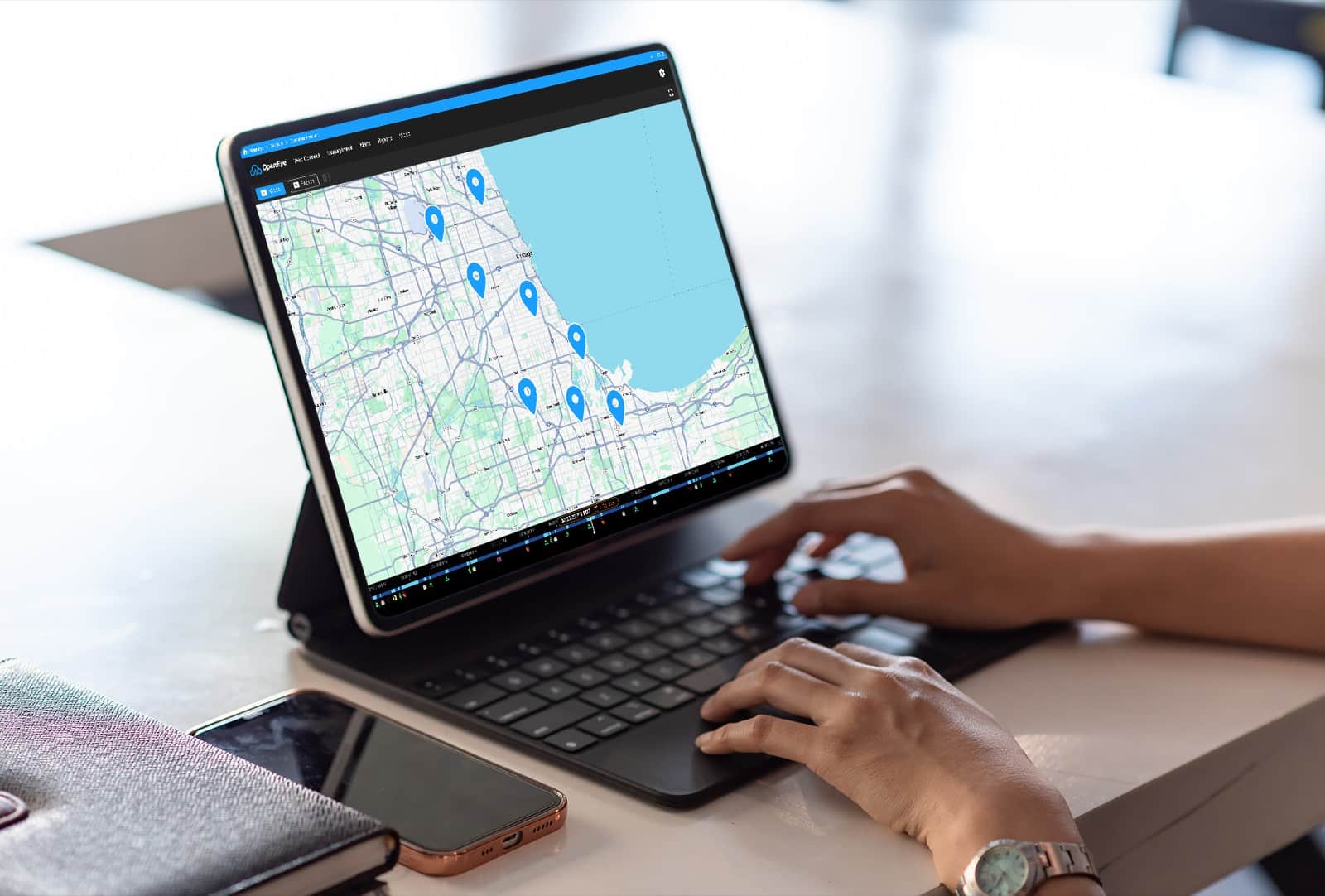 An individual working on a tablet with a map in OpenEye Web Services visible on the screen
