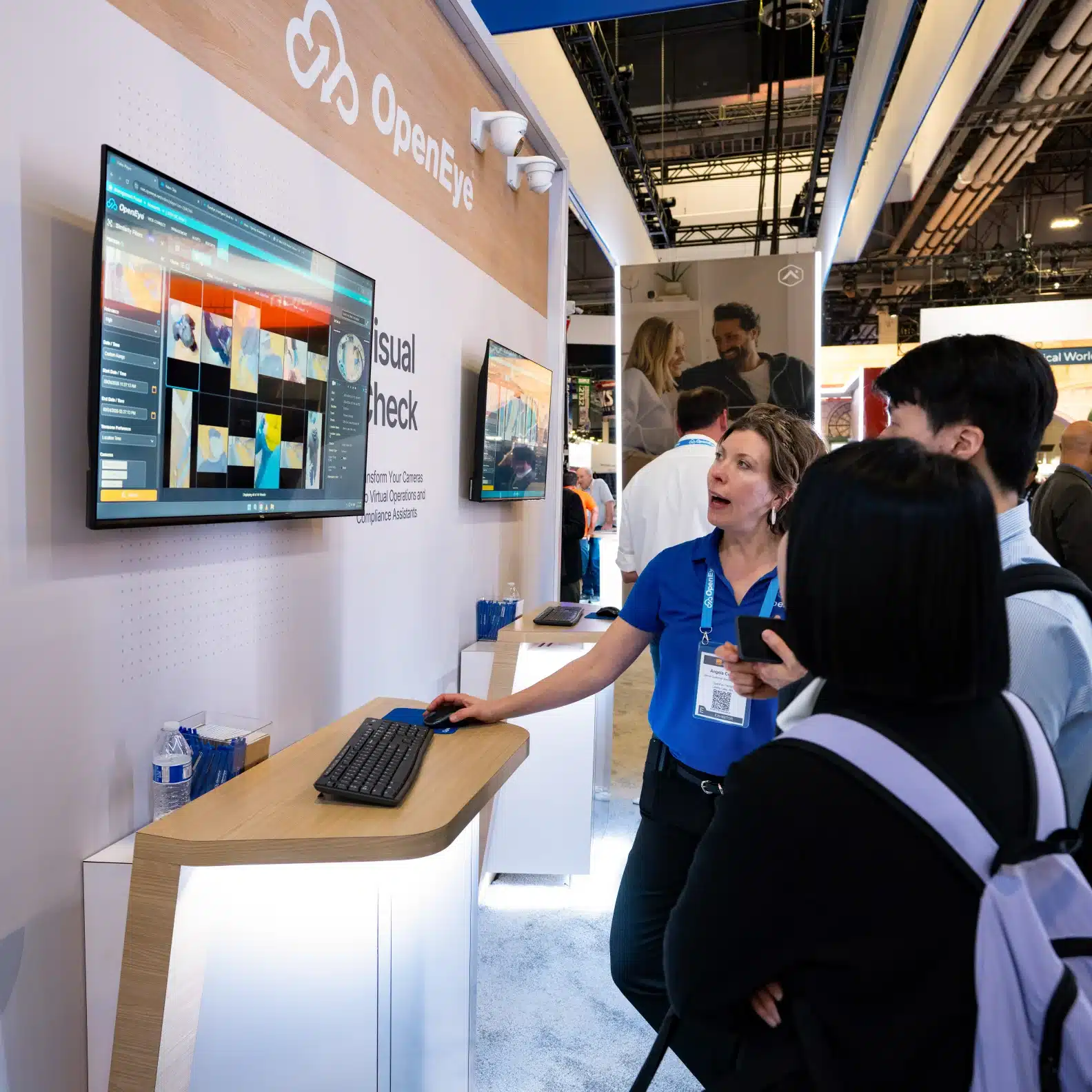 An OpenEye employee gives a live demo of OpenEye Web Services to two people at a trade show