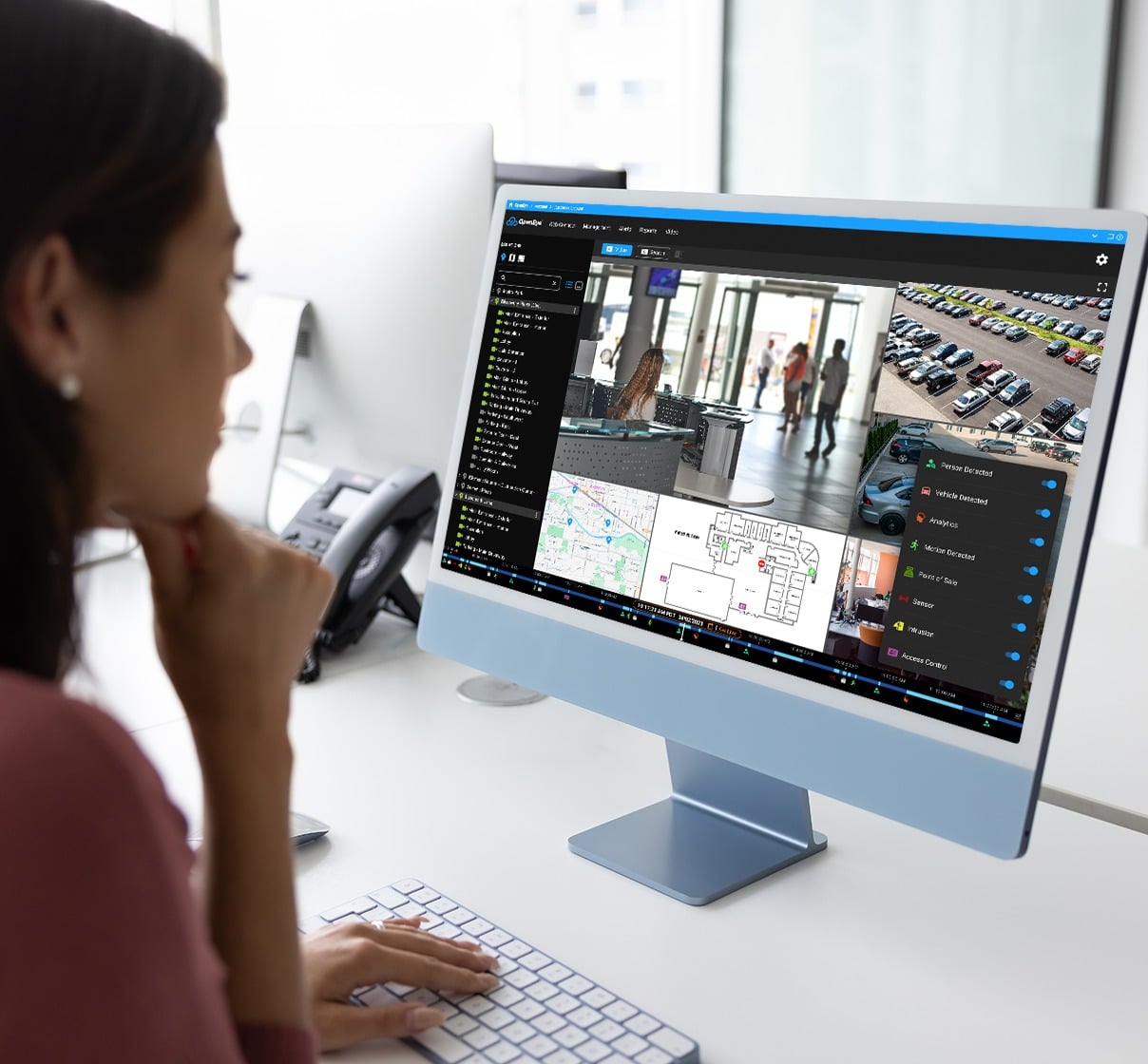 A woman studies a map within OpenEye Web Services on her computer screen