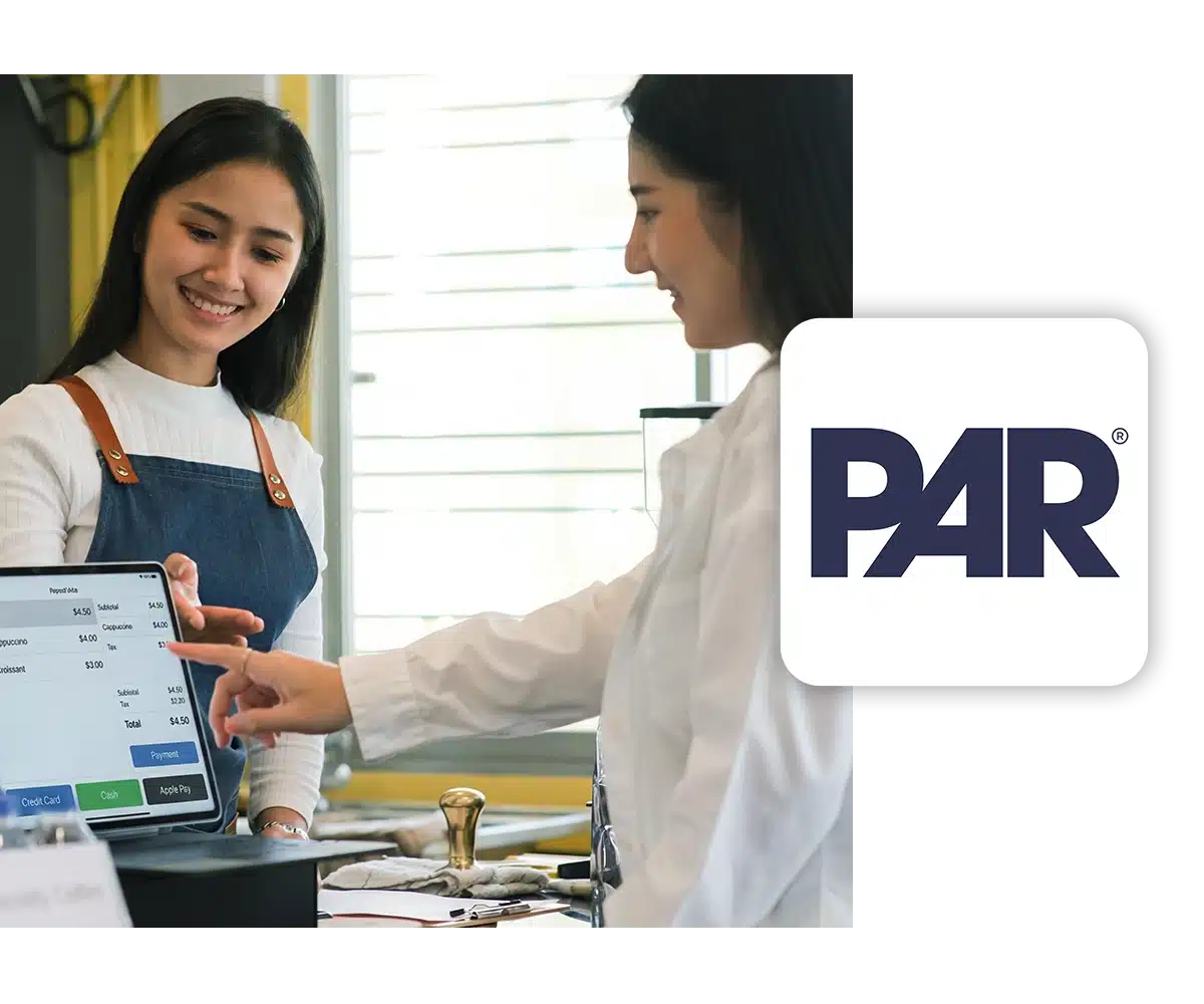 A cashier presents a tablet to a customer to complete their transaction