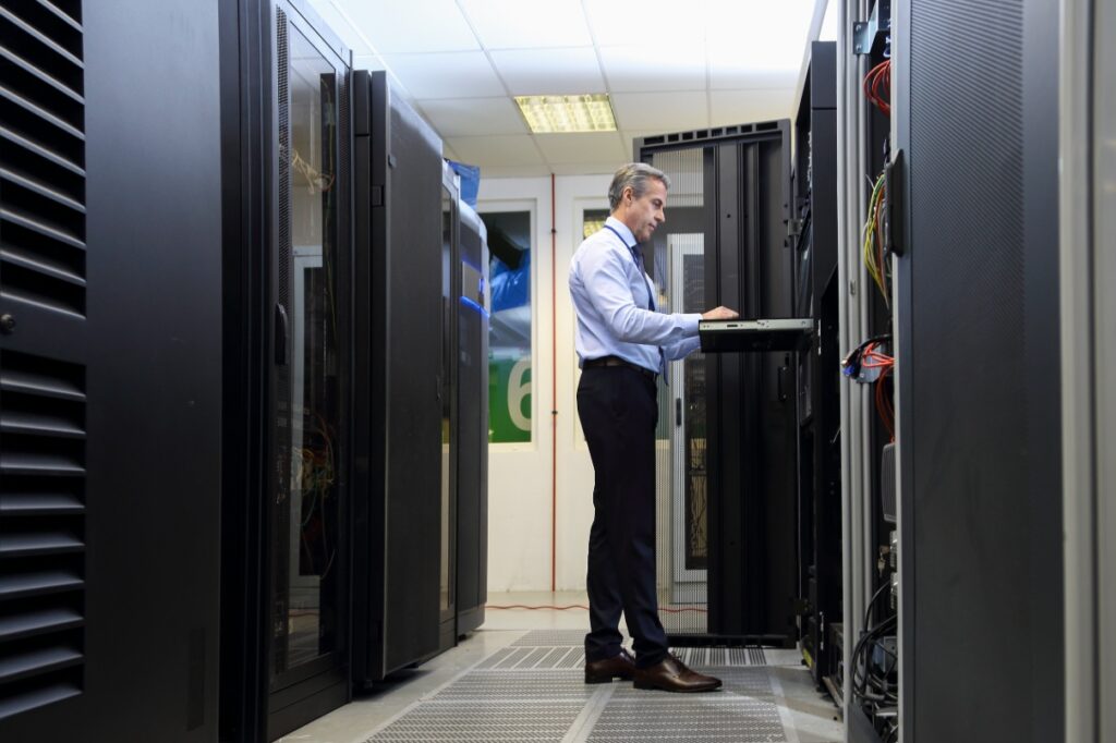 Man standing in front of servers.
