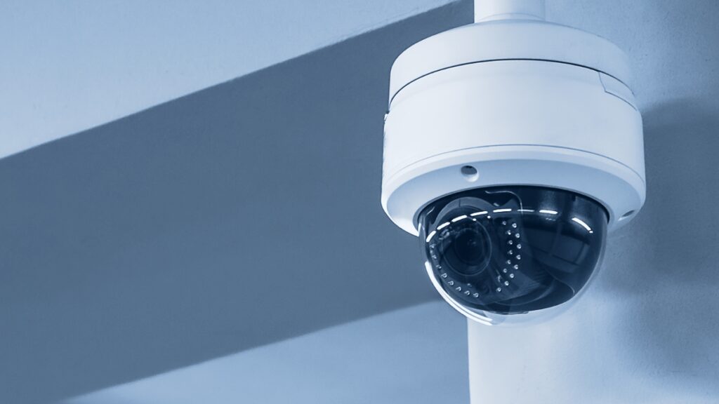 Dome video surveillance camera attached to wall.
