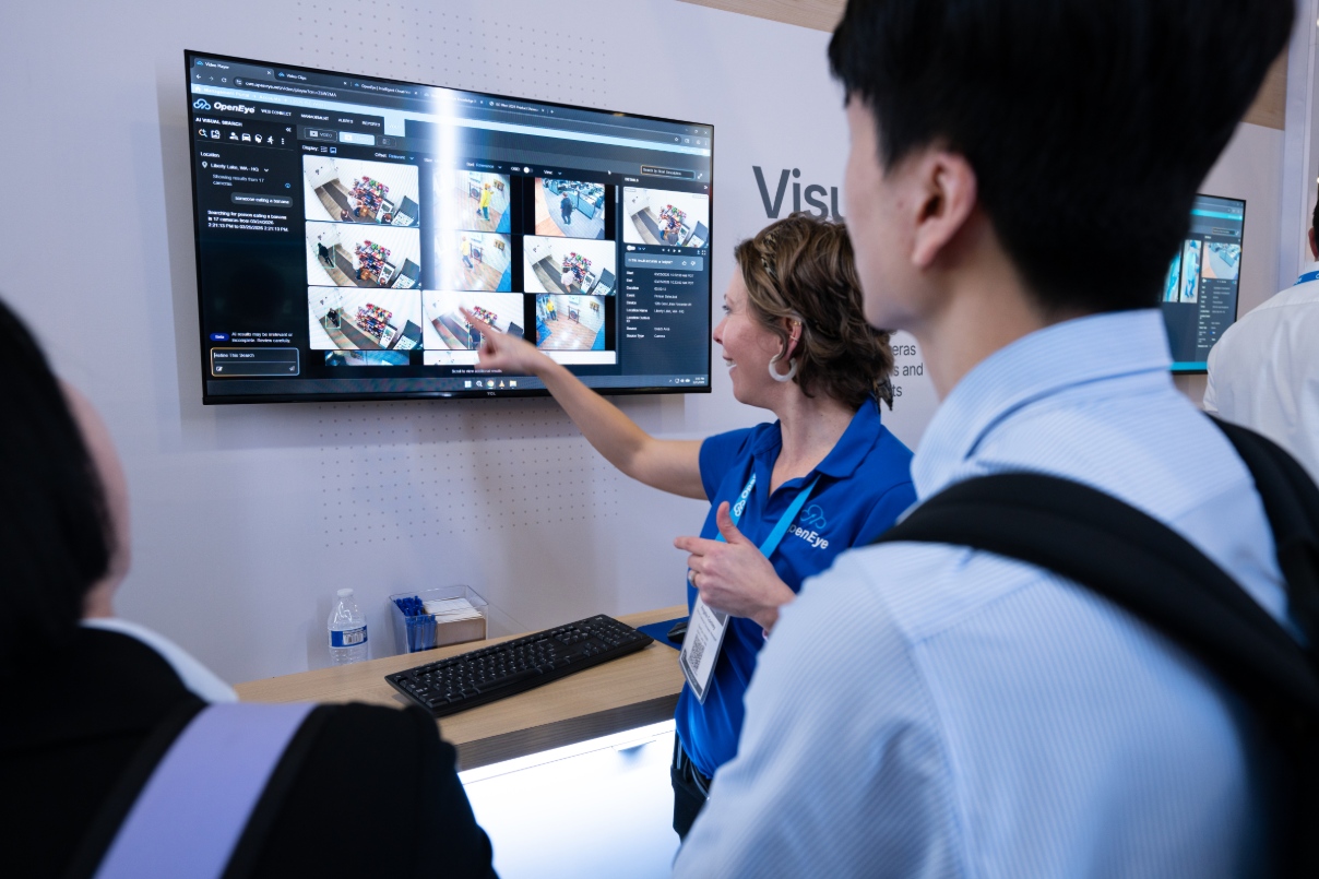 An OpenEye employee demonstrates OpenEye Web Services (OWS) to two individuals at a security trade show.