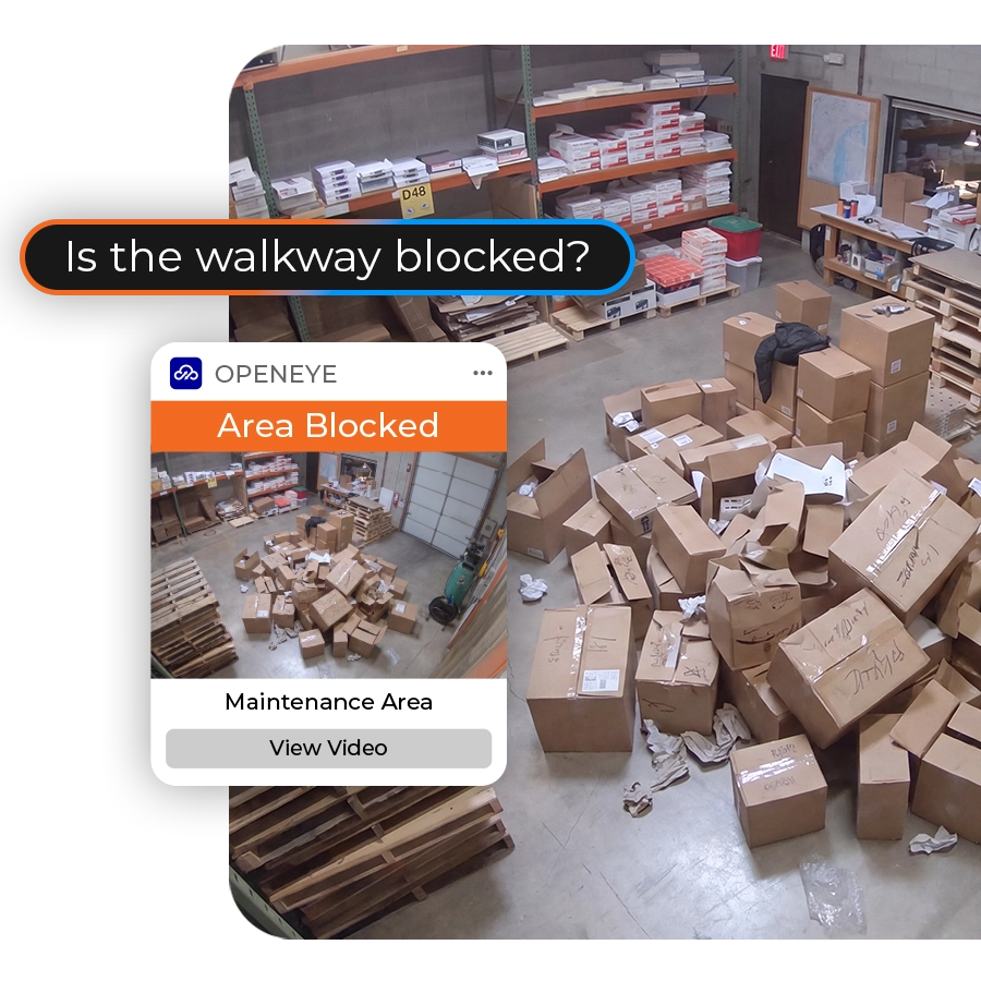 A warehouse scene depicts a pile of boxes blocking the center of a room, with a prompting screen and alert on the left side of the scene reading, "Is the walkway blocked? OPENEYE. Area Blocked. Maintenance Area. View Video."