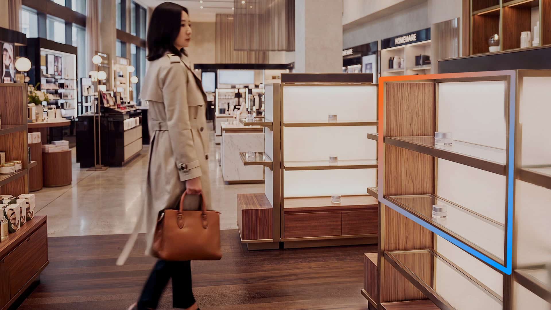 A woman walks past empty shelves in a high end retail store