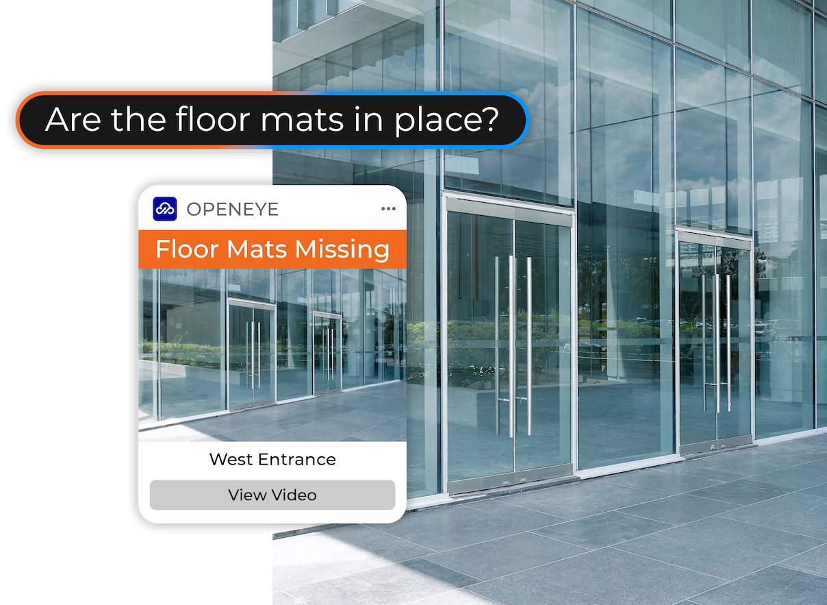 AI Visual Check in OpenEye Web Services (OWS) showing a prompt bar over a scene depicting an outdoor entrance that reads, "Are the floor mats in place?" with an alert on the left side of the scene that reads "OPENEYE. Floor Mats Missing. West Entrance. View Video."