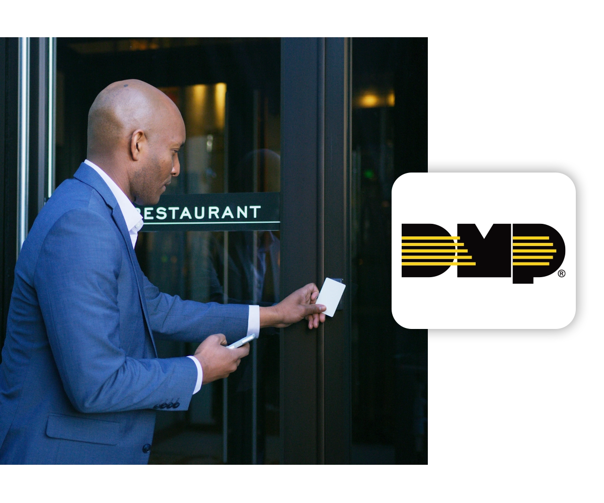 A businessman scans a key card at an access control panel. The DMP logo is on the right side of the image.
